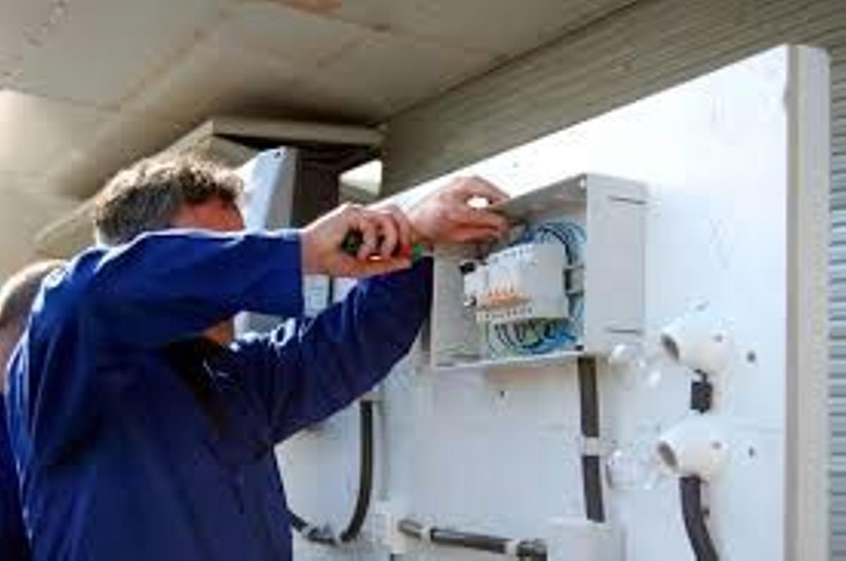 Un operario trabaja en un cuadro eléctrico.