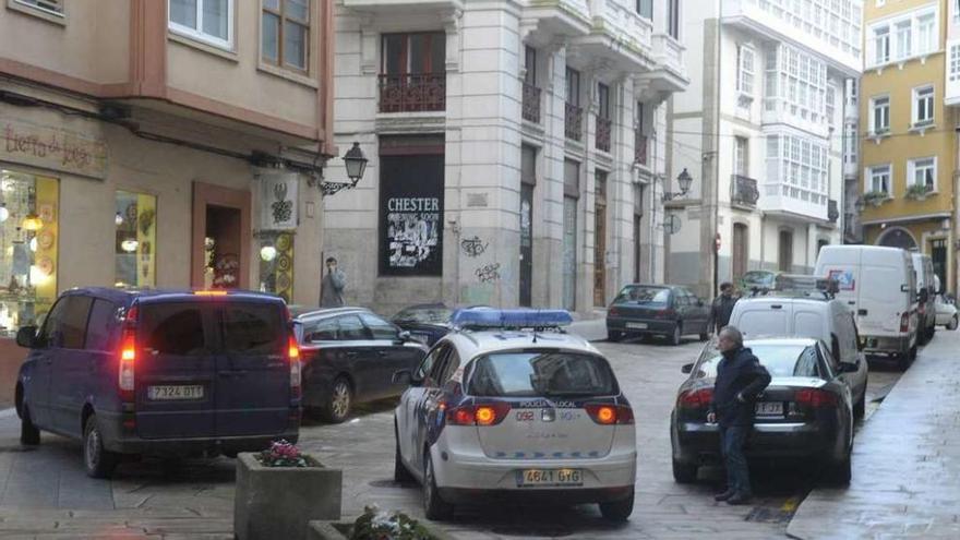 Un coche policial vigila los coches estacionados sin permiso en Ciudad Vieja.