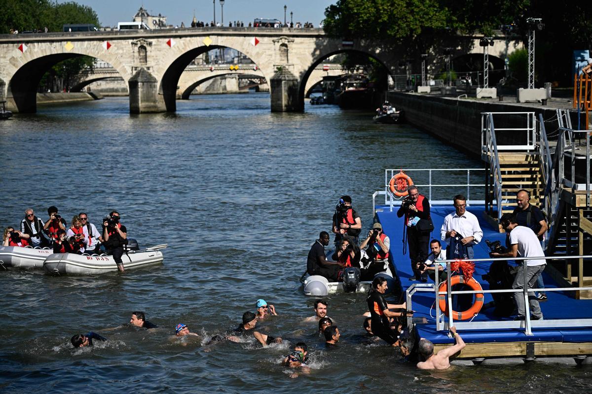 Paris Mayor Anne Hidalgo climbs the ladder after swimming in the Seine, in Paris on July 17, 2024, to demonstrate that the river is clean enough to host the outdoor swimming events at the Paris Olympics later this month. Despite an investment of 1.4 billion euros ($1.5 billion) to prevent sewage leaks into the waterway, the Seine has been causing suspense in the run-up to the opening of the Paris Games on July 26 after repeatedly failing water quality tests. But since the beginning of July, with heavy rains finally giving way to sunnier weather, samples have shown the river to be ready for the open-water swimming and triathlon -- and for 65-year-old Hidalgo. (Photo by JULIEN DE ROSA / AFP)