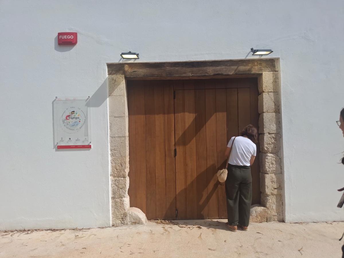 La concejala Maria Josep Ripoll abre la puerta de atrás de la casa de Torrecremada
