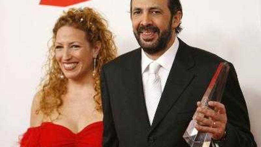 Juan Luis Guerra muestra orgulloso el premio junto a su mujer.