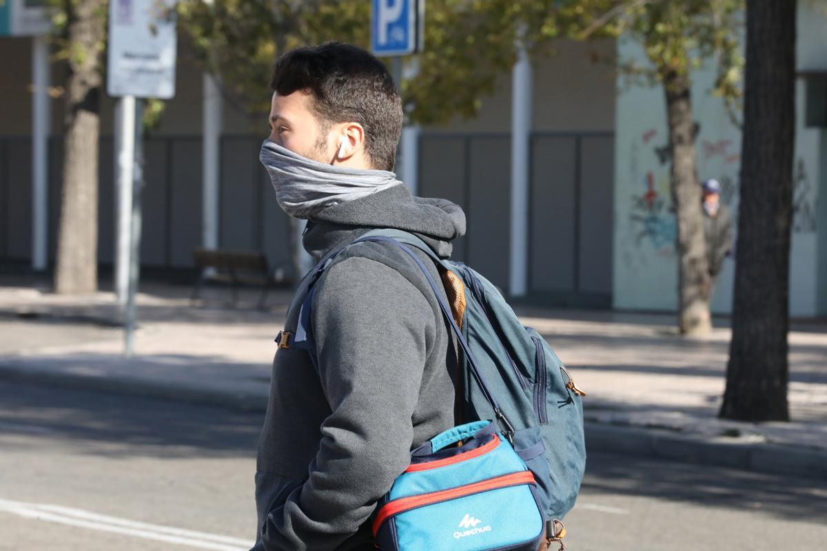 Un joven se abriga la cara, protegiéndose del frío, foto de recurso.