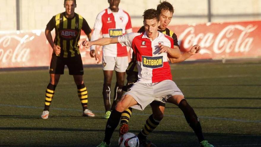 El juvenil Óscar protege un balón ayer en el Baltasar Pujales, con Sylla siguiendo la jugada en segundo término. // José Lores