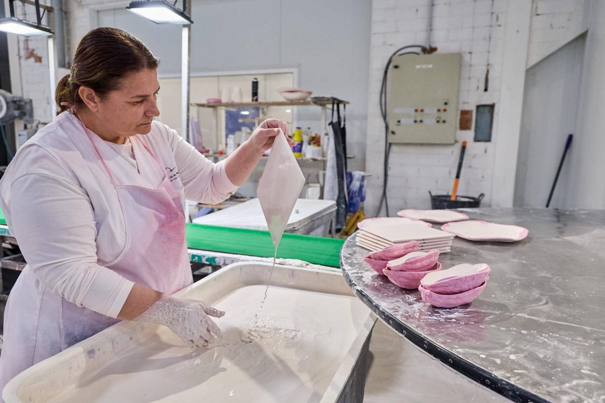 Una de les treballadores de Pordamsa aplicant el vernís manualment.