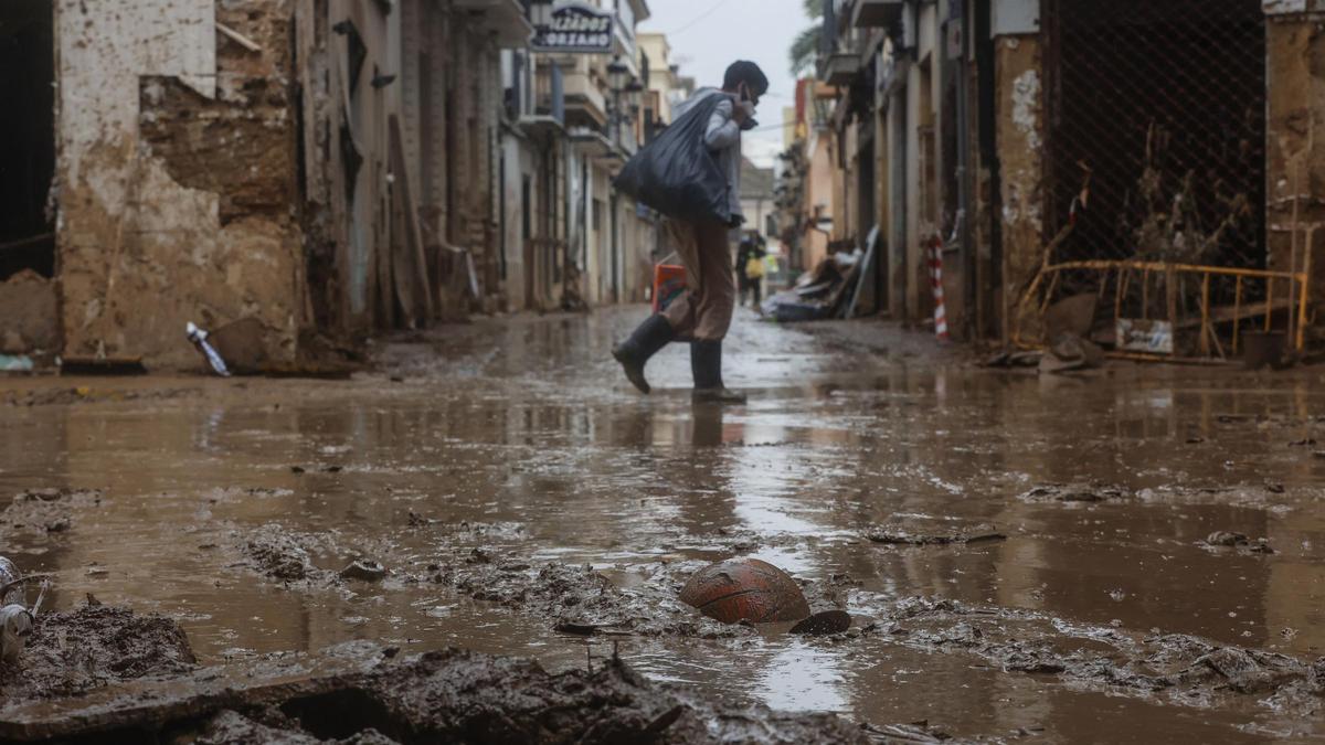 Un hombre pasea por la calle anegada de barro el 13 de noviembre de 2024, en Paiporta, Valencia, Comunidad Valenciana