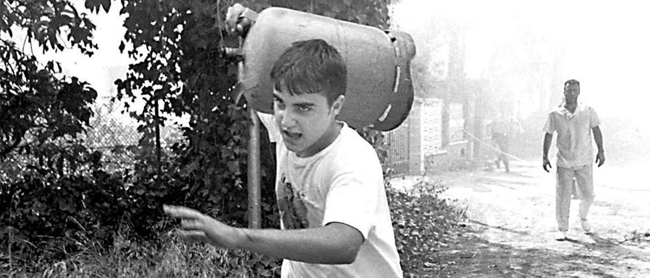 Un vecino de La Vallesa huye del fuego cargando una bombona de butano durante los incendios de 1994.