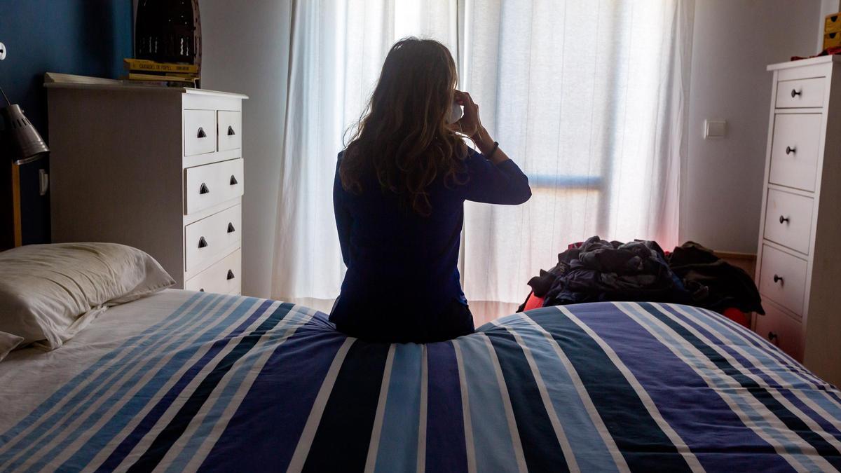 Una mujer pide ayuda por teléfono desde su habitación