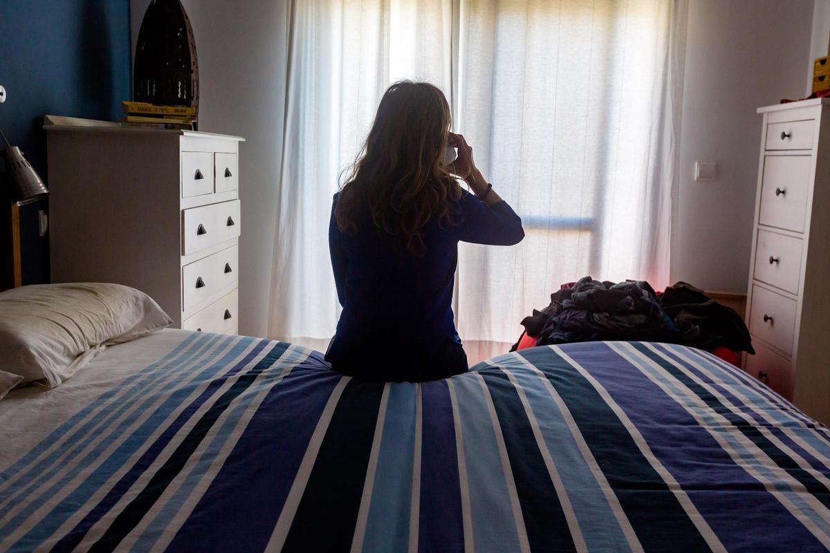 Una mujer pide ayuda por teléfono desde su habitación