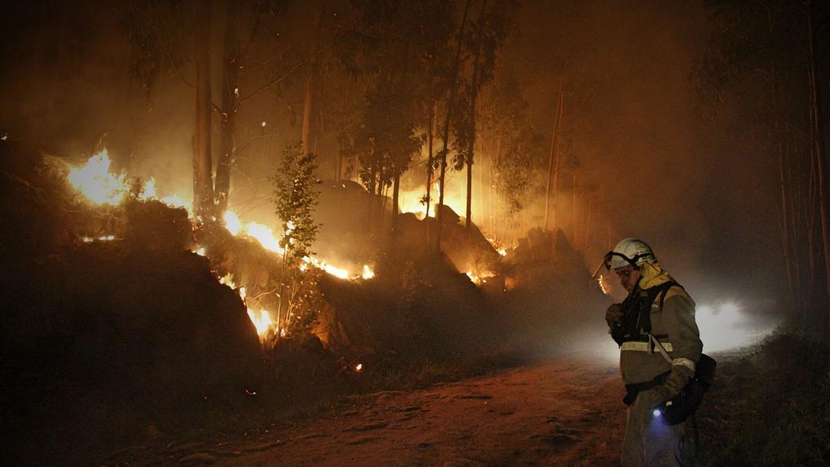 Un brigadista en un incendio de noche en Moaña.