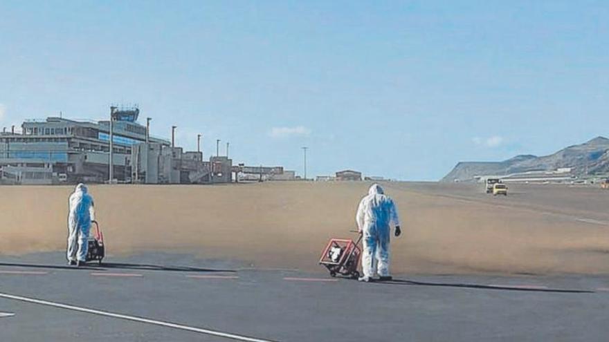 Operarios de limpieza retiran ceniza de la pista del aeropuerto de La Palma durante la erupción.