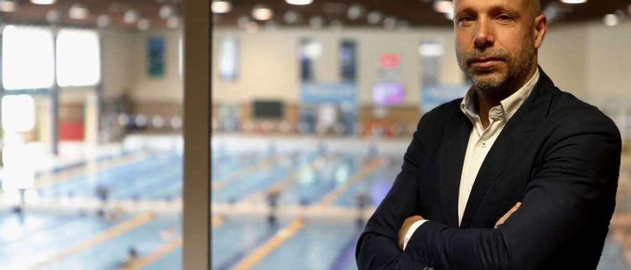 Secundino González posa en las instalaciones del Club Natación Santa Olaya, con la piscina olímpica a su espalda.