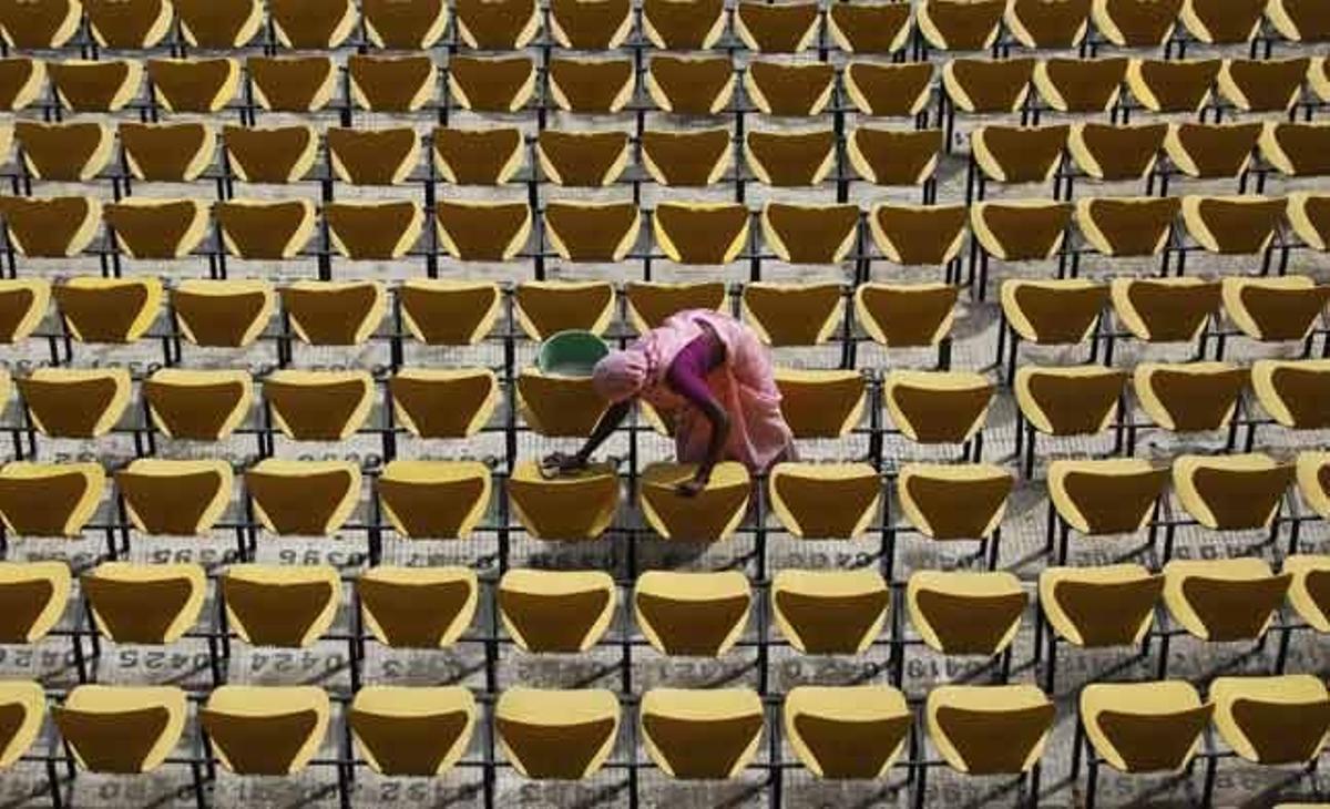 Una dona neteja els seients de l’estadi de l’associació de criquet Vidarbha abans del partit entre l’Índia i Nova Zelanda a Nagpur (Índia).