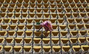 Una dona neteja els seients de l’estadi de l’associació de criquet Vidarbha abans del partit entre l’Índia i Nova Zelanda a Nagpur (Índia).