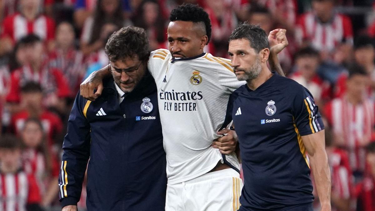 Éder Militao se retira lesionado de San Mamés, ayudado por los médicos del Real Madrid.