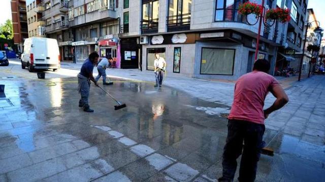 El viernes los operarios ya acabaron de colocar las losas en Arapiles y Ramón y Cajal y baldearon sendas calles. // Iñaki Abella