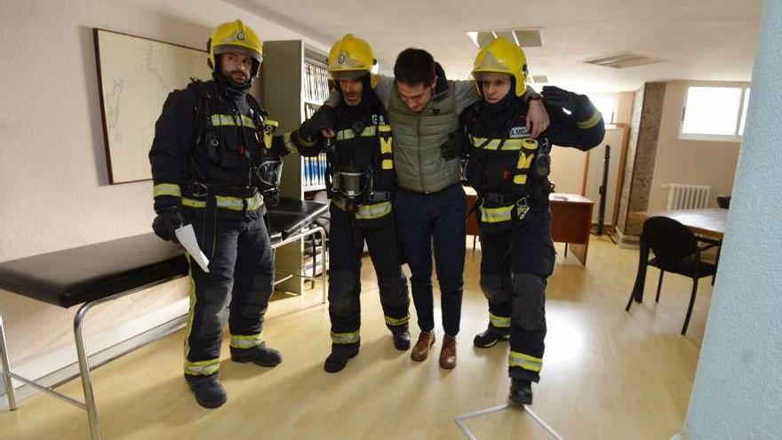 Los bomberos ayudan a un supuesto lesionado en las maniobras de ayer. // G. Santos