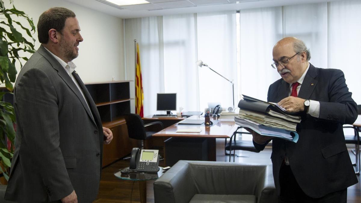 Andreu Mas-Colell (derecha) entrega documentación a su sucesor al frente de la Conselleria d'Economia, Oriol Junqueras, el 14 de enero del 2016, día del traspaso de carteras.