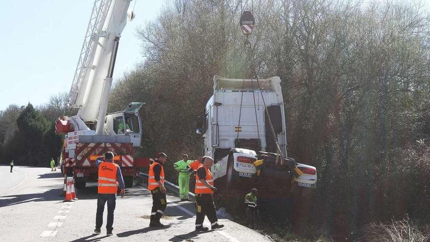 Una grúa de gran tonelaje izó el camión siniestrado en la cuneta de la N-525. Primero devolvió a la calzada el remolque y posteriormente retiró la cabina. La carga había sido recuperada por la mañana. // Iñaki Osorio