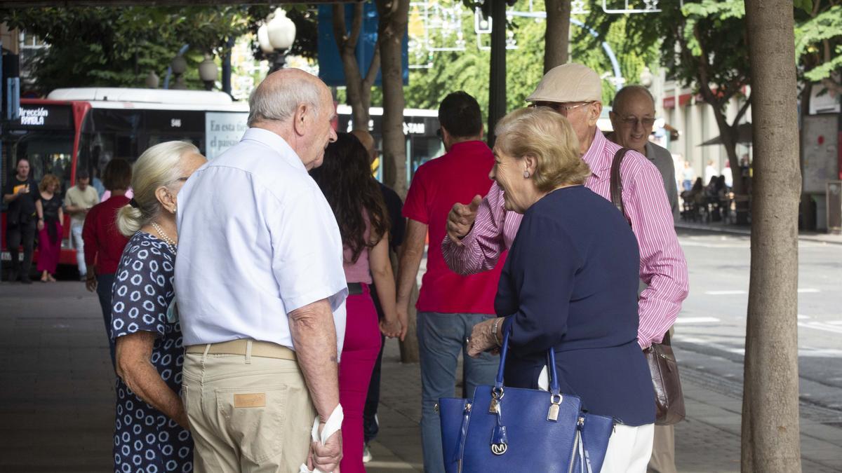 Un grupo de personas mayores charlando en una calle de Alicante