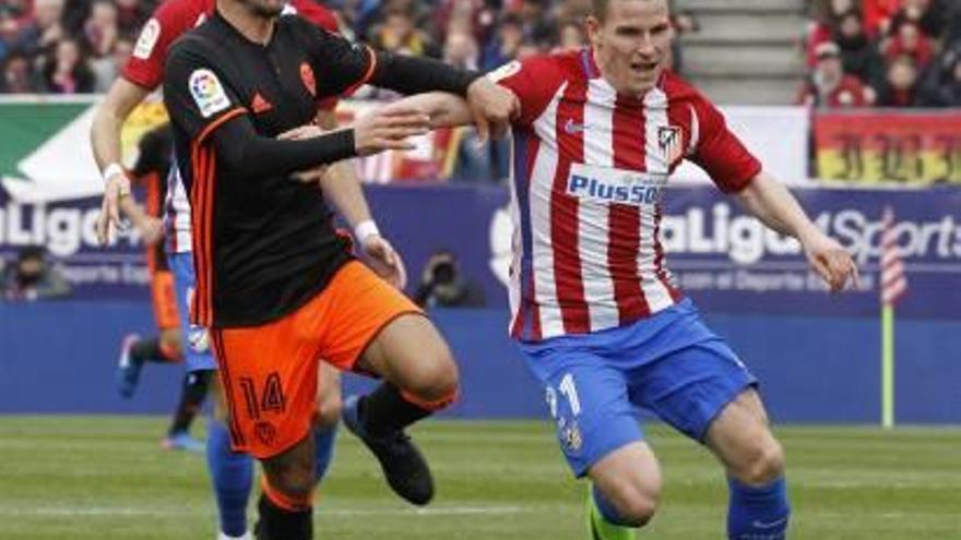 Gameiro intenta ganar la posición ante Gayà en la última visita del Valencia CF al Atlético de Madrid.