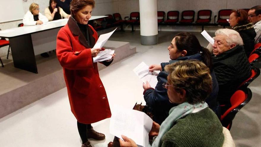 Charo Fernández reparte los resultados de la encuesta entre los asistentes.