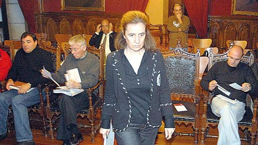 La alcaldesa se traslada a la mesa para presidir el pleno en el salón noble municipal.