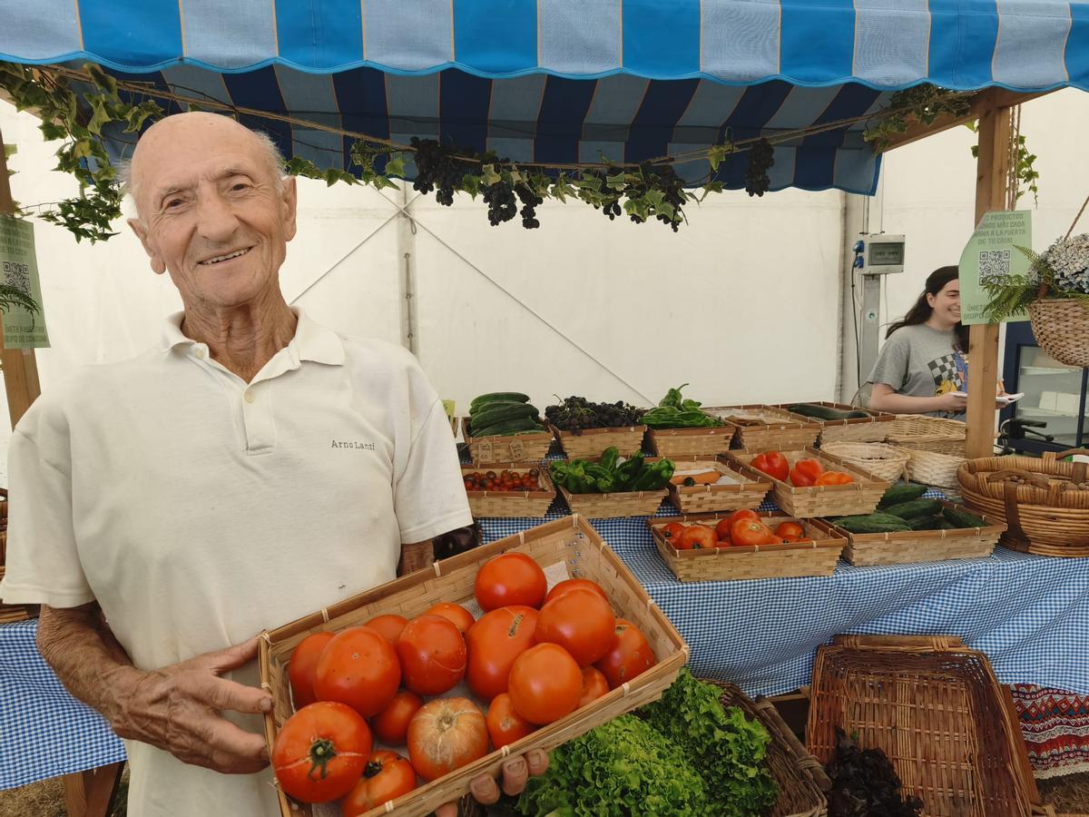 Santiago Pérez muestra una cesta de tomate en la Feria Ecológica de Llanera.