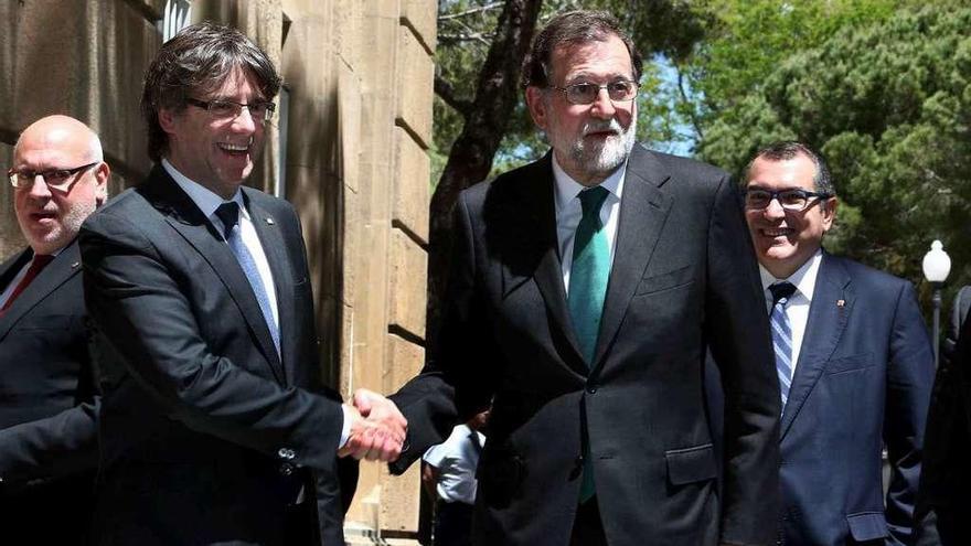 Puigdemont y Rajoy se saludan en el Salón del Automóvil de Barcelona, ayer. // Efe