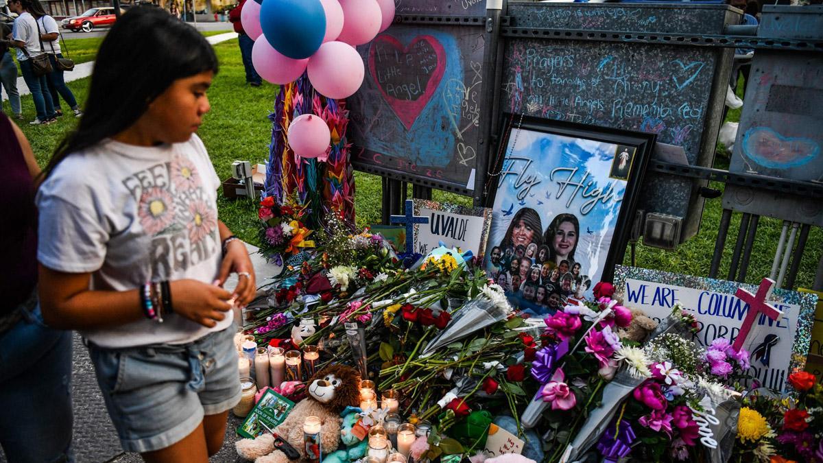 Una niña visita un monumento improvisado para las víctimas del tiroteo fuera del juzgado del condado de Uvalde en Texas el 28 de mayo de 2022. (Foto de CHANDAN KHANNA / AFP)