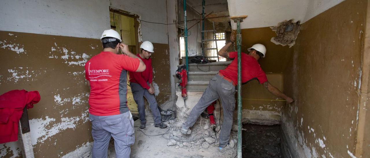 Unos albañiles, en plenos trabajos de reforma, en un edificio del Port de Sagunt. | DANIEL TORTAJADA