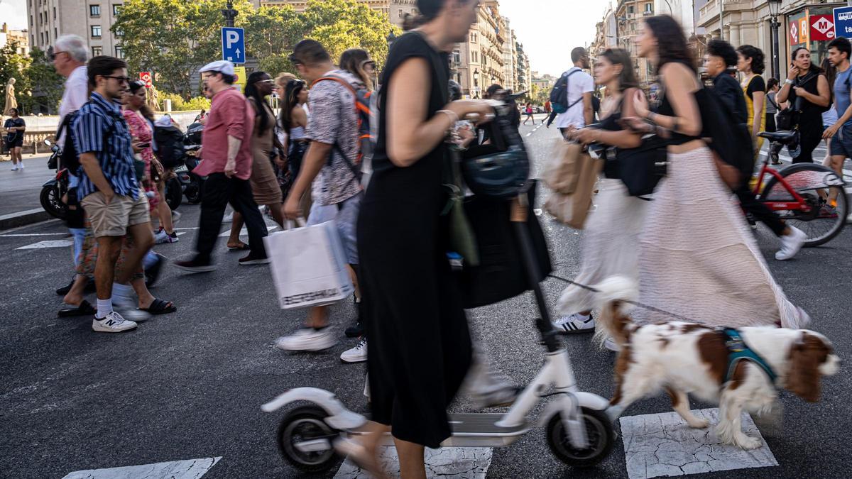 Peatones, patinete elécrico y bici cruzando una calle en Barcelona,a finales de agosto pasado.