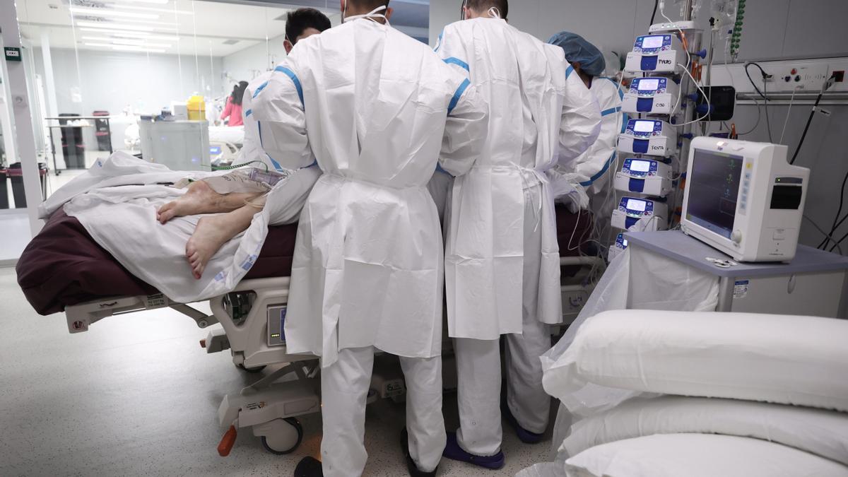 Varios enfermeros atienden a una paciente en la UCI.