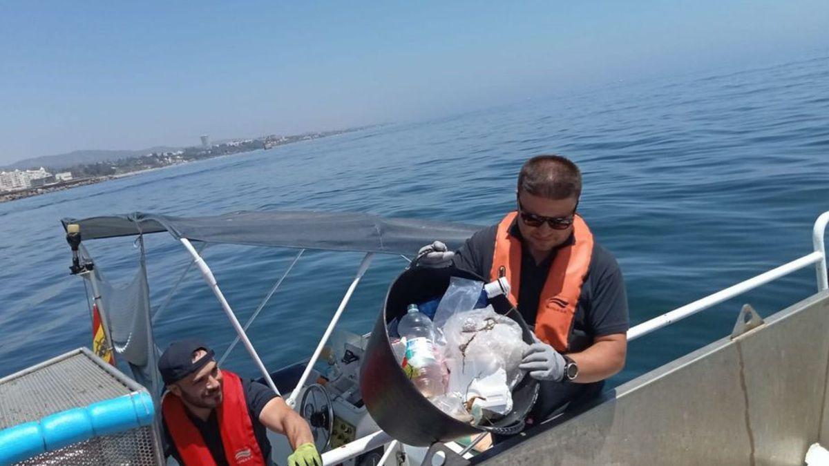 Un operario descarga un cubo con restos plásticos.