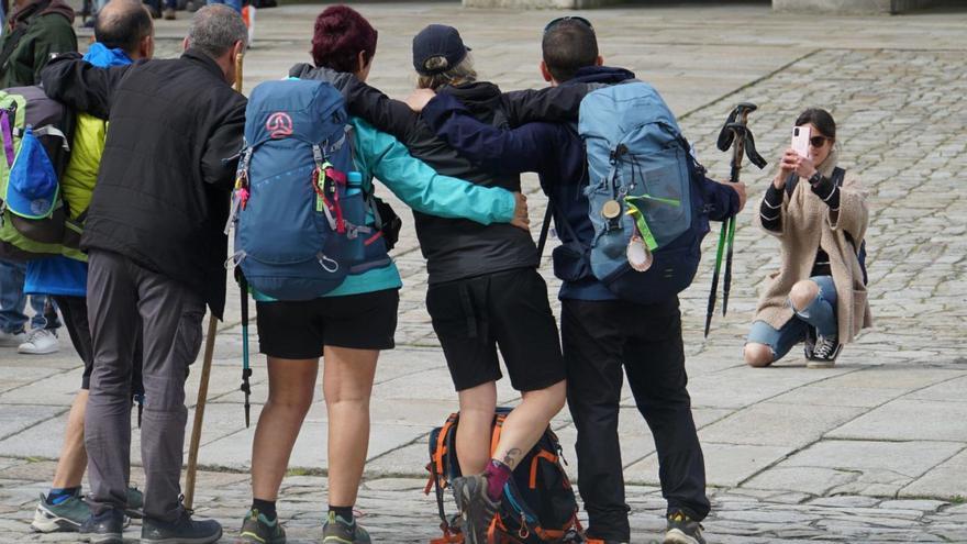 Peregrinos sacándose una foto tras llegar a la compostelana Praza do Obradoiro /jesús prieto