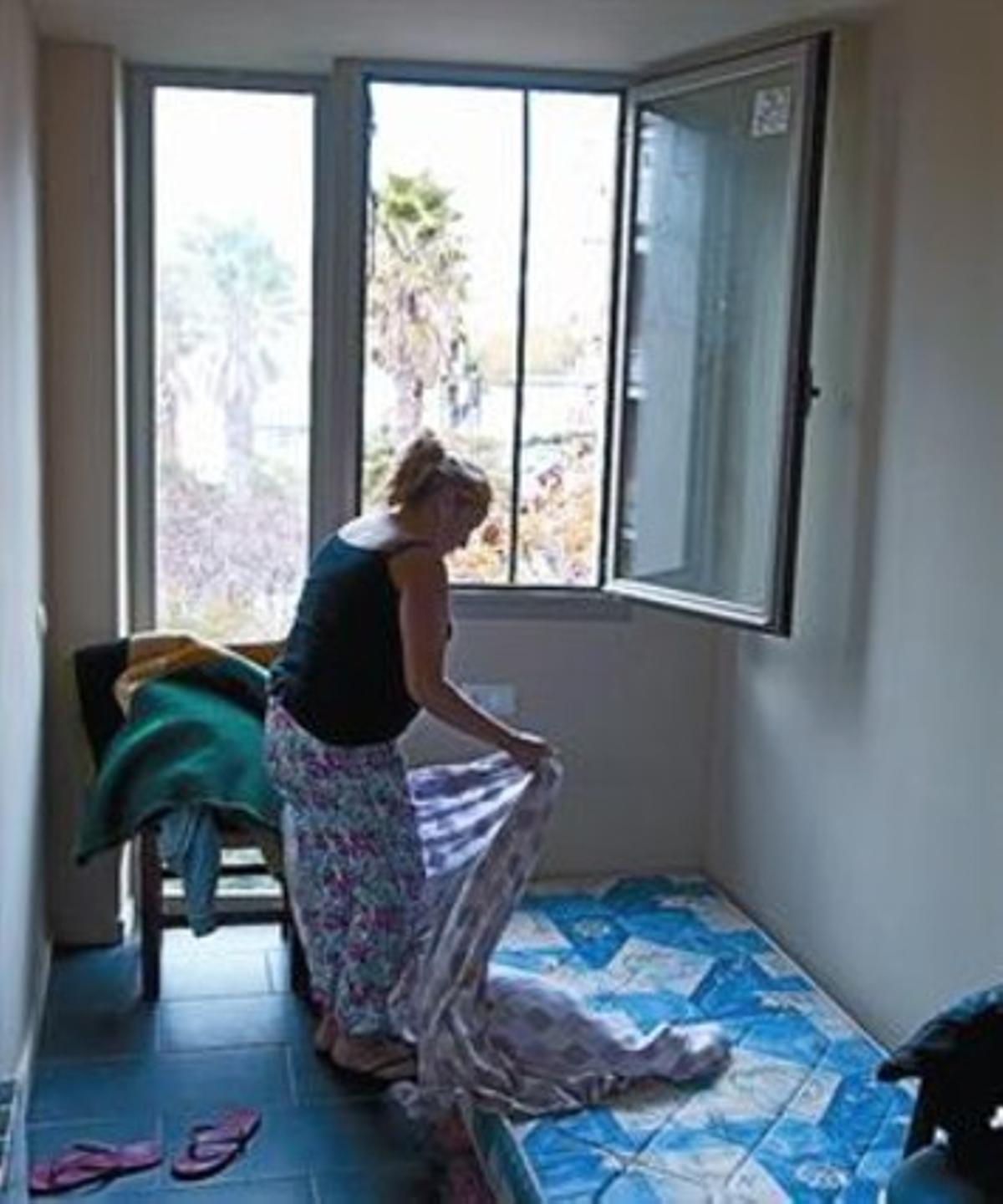 Patricia, una de les residents a l’edifici, prepara un llit. Patricia, una de les residents a l’edifici, prepara un llit.