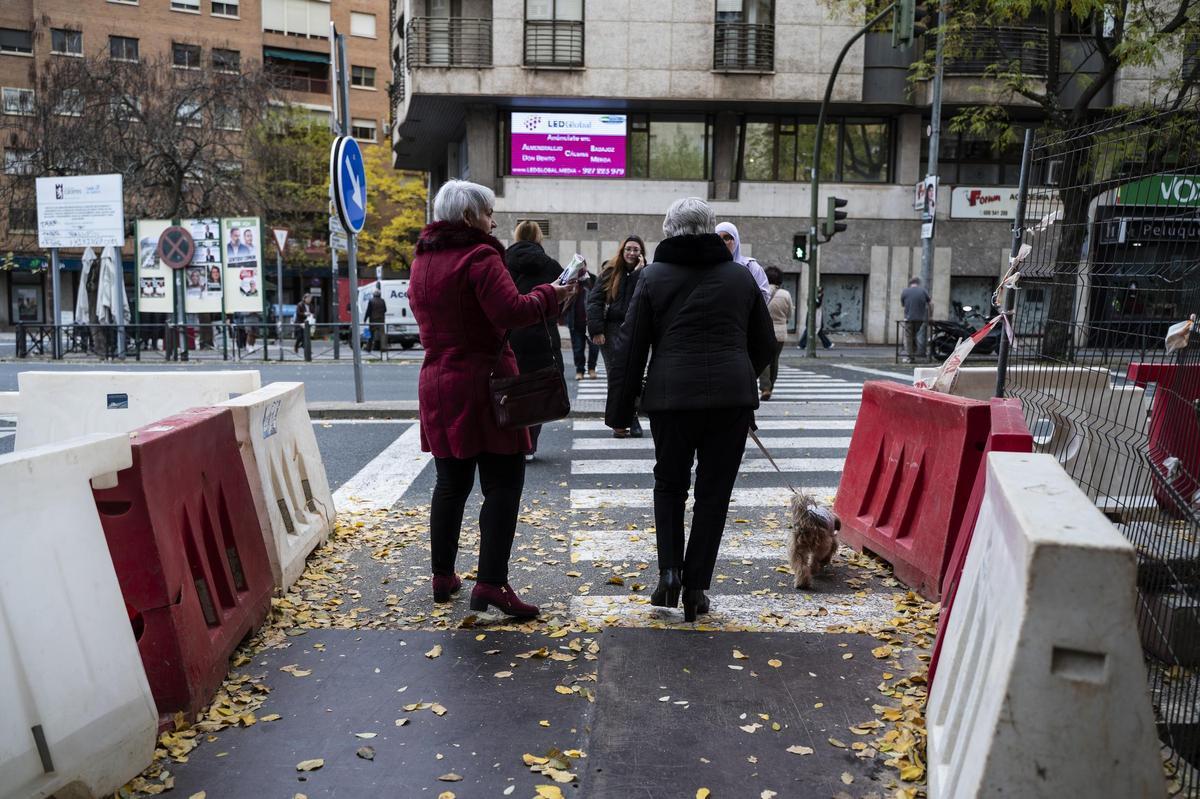 Varios residentes atraviesan el paso de peatones junto a las obras de la avenida Alemania.