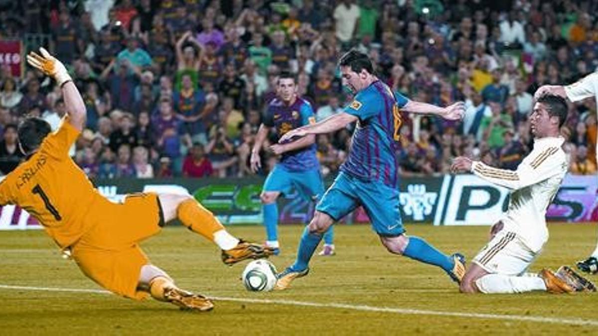 Messi pica el balón ante la salida desesperada de Casillas en la acción del segundo gol mientras Ronaldo cae arrodillado a su espalda, anoche en el Camp Nou.