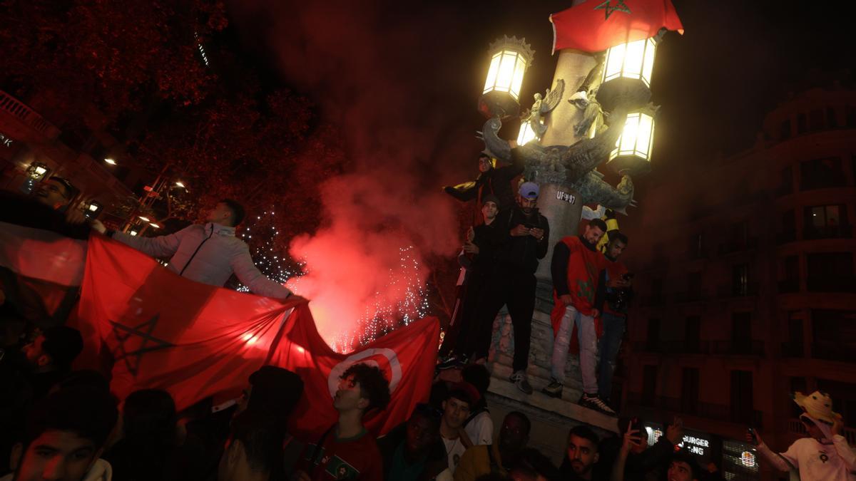 Seguidores marroquís celebran la victoria ante España en plaza Catalunya.