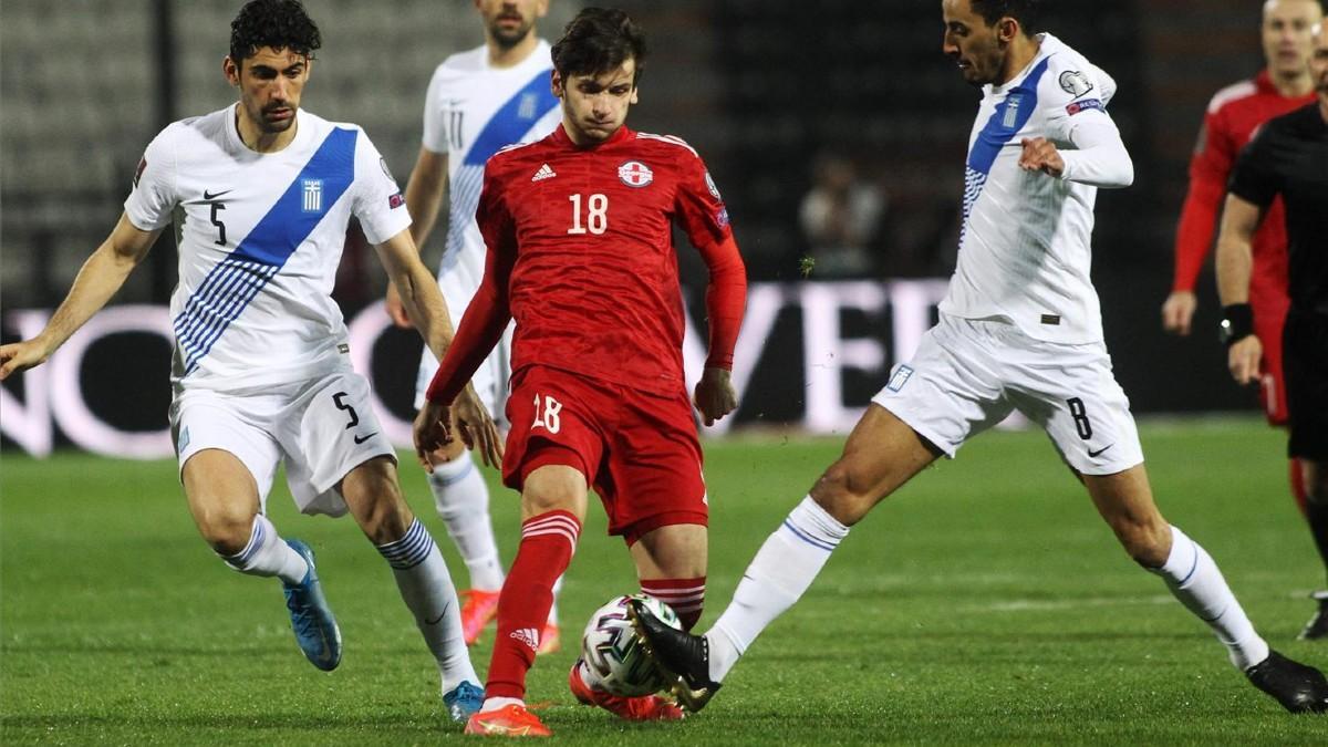 Kvaratskhelia pele por un balón con Zeca durante el Georgia - Grecia