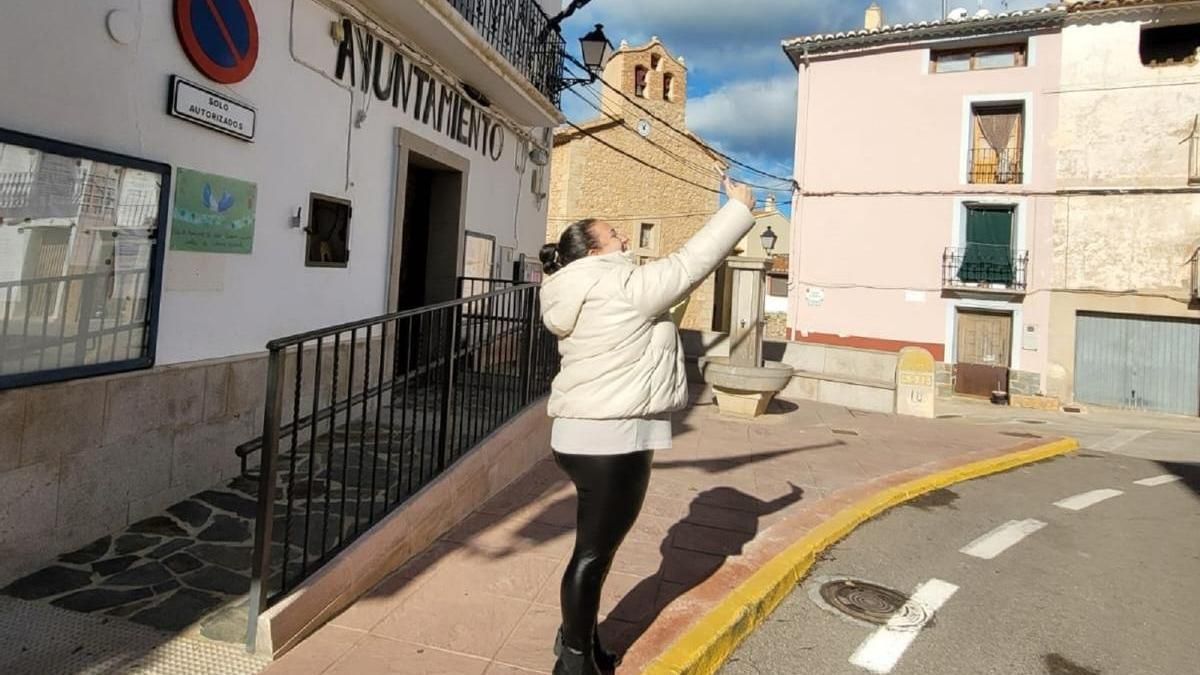 Una empleada del Ayuntamiento trata de encontrar cobertura, sin éxito, al lado del edificio consistorial de Fuente la Reina.