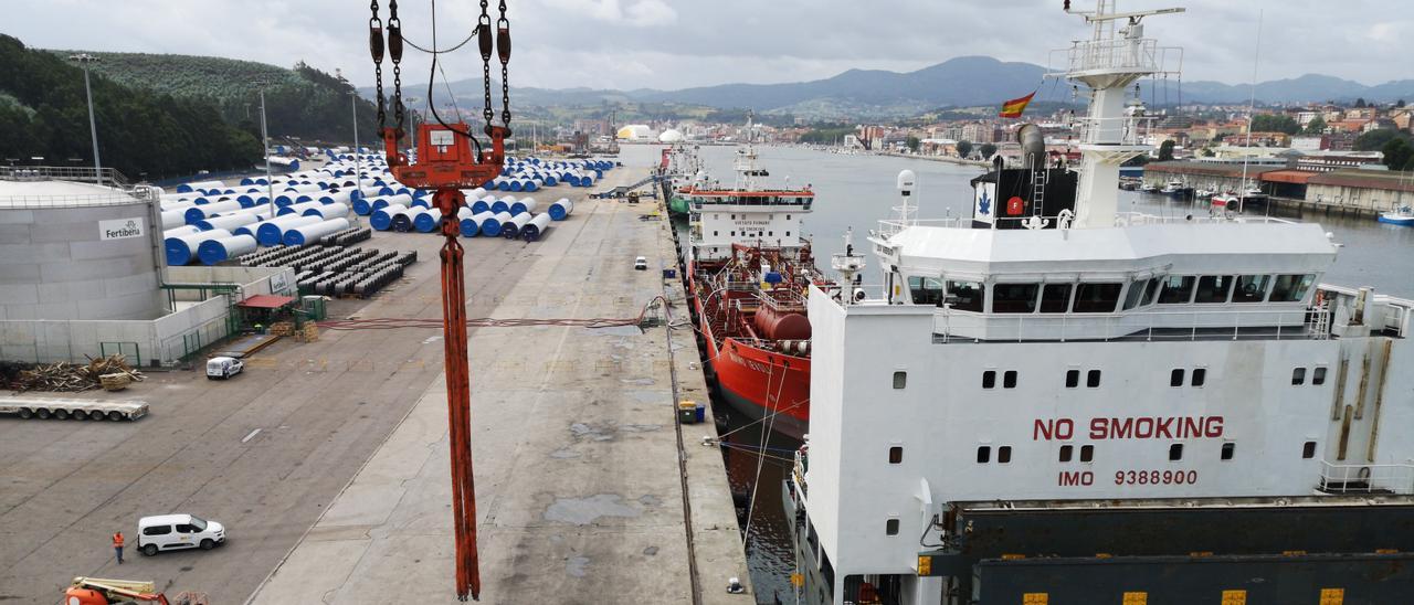 Tramos de torres eóliques nel puertu avilesín, col Centru Niemeyer al fondu de la ría.