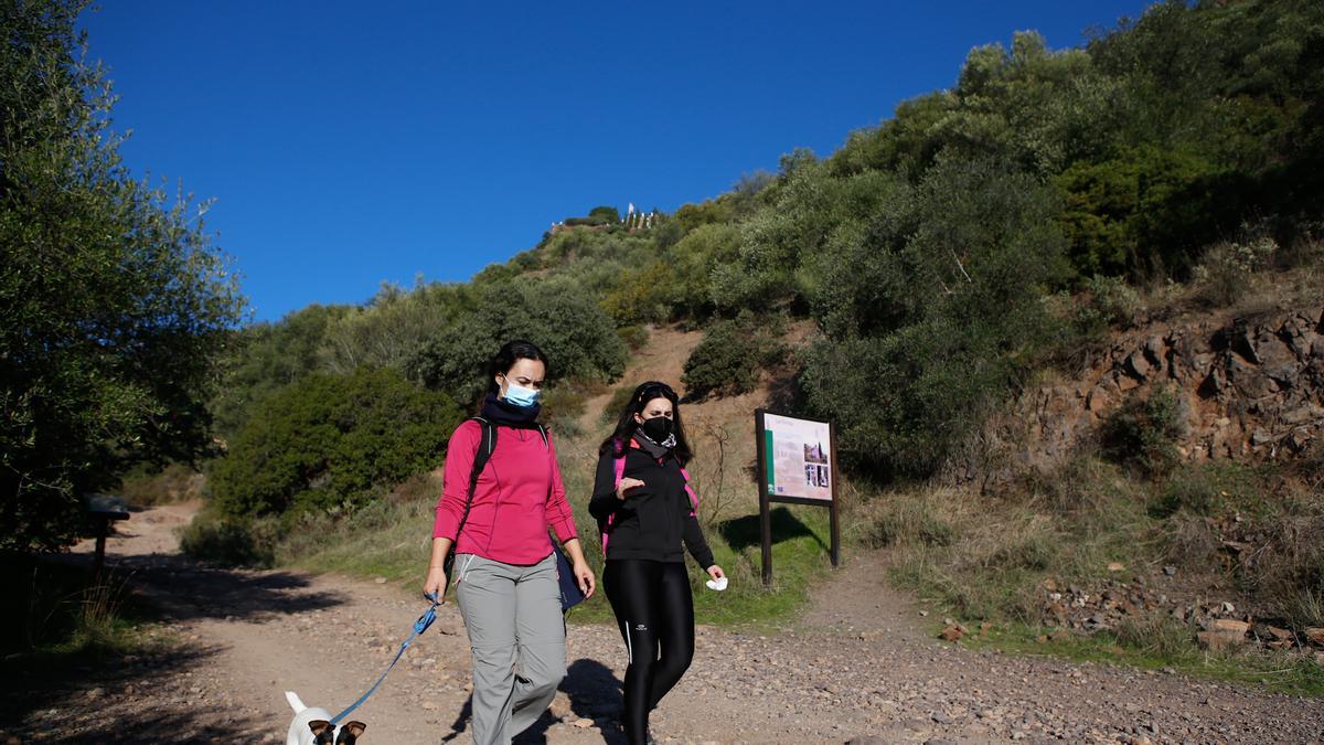 Dos jóvenes hacen senderismo por un camino en las inmediaciones de Córdoba.