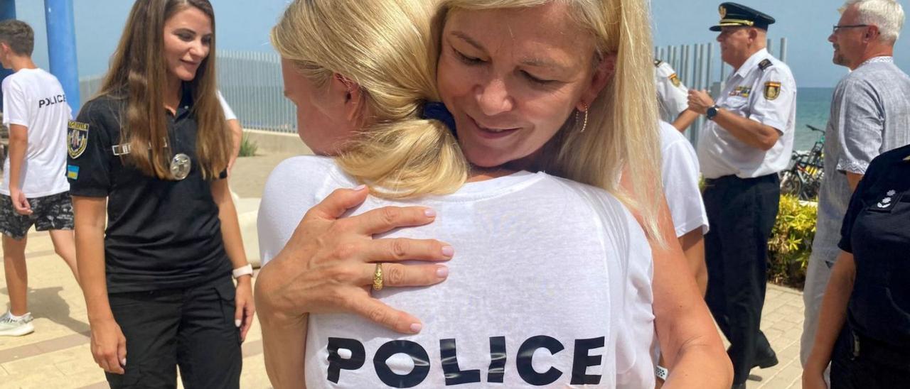 La consellera Gabriela Bravo abraza a una joven ucraniana, ayer en el albergue Mar i Vent de Piles. A la derecha, con otros acogidos y policías nacionales españoles. | LEVANTE-EMV