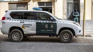 Archivo - Un vehículo y un agente de la Guardia Civil durante una operación de la Guardia Civil
