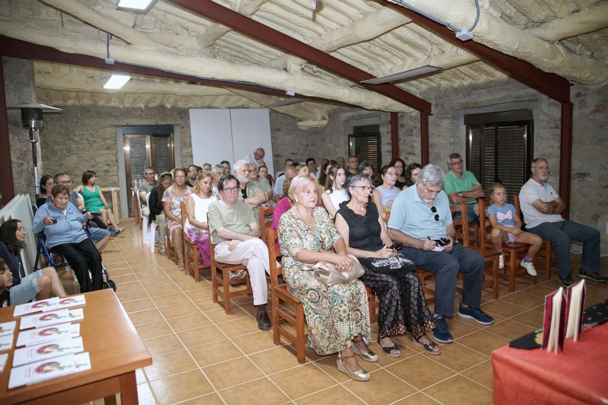 Vecinos de la localidad siguen con atención la presentación del poemario.
