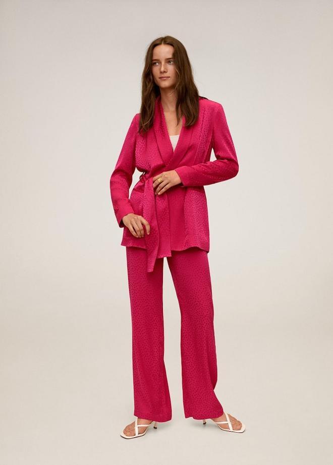 Traje satinado de color rosa fucsia con americana con lazo y pantalón ancho, de Mango