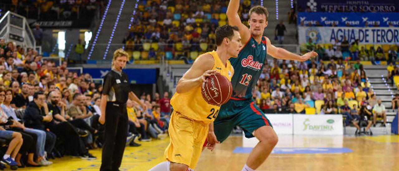 El escolta estadounidense del Granca Kyle Kuric (i) penetra a canasta ante Balvin, del Baloncesto Sevilla.