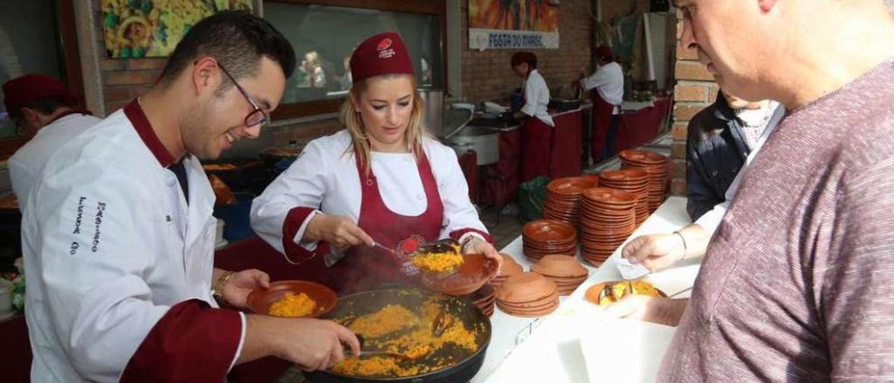 Los cocineros sirven unas raciones de arroz de mariscos, ayer. // Muñiz