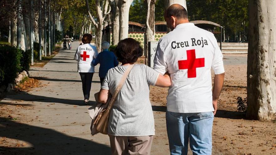 Voluntaris de la Creu Roja fent un acompanyament a persones grans