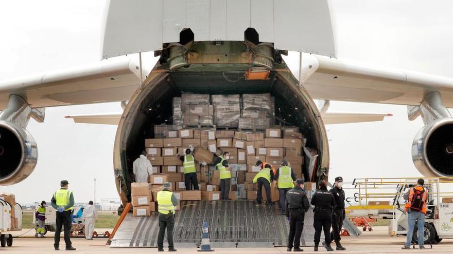 Autoridades revisan un avión con material sanitario.